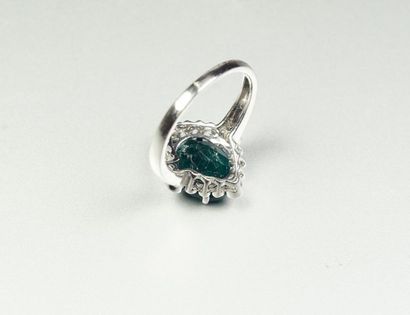 null 18K (750/oo) white gold ring centered on an oval emerald calibrating approximately...