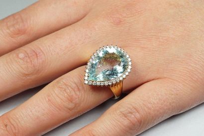 null Two-tone 18K (750/oo) gold ring centered on a 6.25 carat aquamarine in a setting...