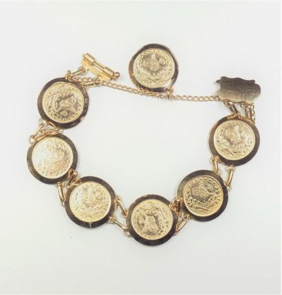 null 18K (750/oo) yellow gold bracelet with articulated links centered on 7 coins...