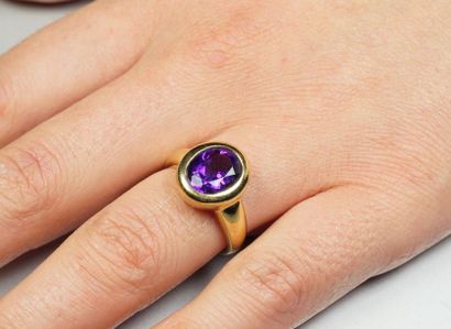null 18K (750/oo) yellow gold ring centered on an oval amethyst in a closed setting....
