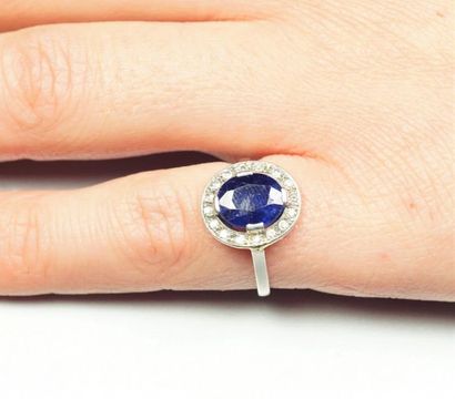 null Platinum ring (850/oo) centered on an oval sapphire calibrating approximately...