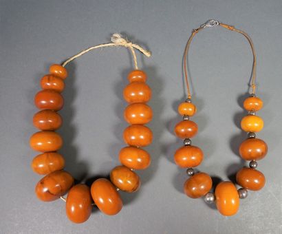 null Lot de deux colliers composés d'importantes perles de copal.