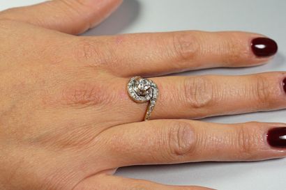 null Bague "Tourbillon" en or 18K (750/oo) de deux tons centrée d'un diamant taille...