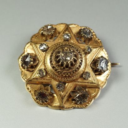 null Broche ancienne en or jaune 18K (750/oo) ciselé à décor festonné et ajouré centré...