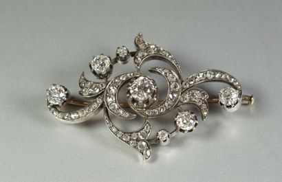 null Broche ancienne en argent (800/oo) partiellement vermeillé à décor de volutes...