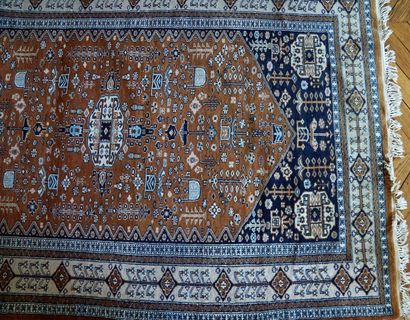 null Oriental carpet with geometric decoration on a chocolate and navy background...