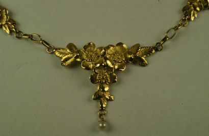 null Collier draperie en or jaune ciselé à décor de fleurs agrémenté d'une perle....