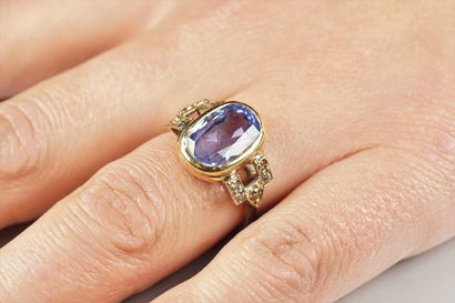 null An 18K (750/oo) gold two-tone ring centered with an oval sapphire weighing approximately...