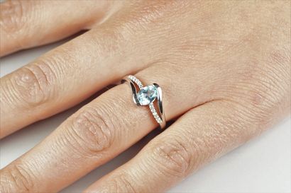 null Silver (925/oo) cross ring centered with an oval blue topaz surrounded by lines...