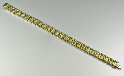 null Bracelet ligne en or jaune 18K (750/oo), chaque maillon serti d'un péridot rectangulaire...