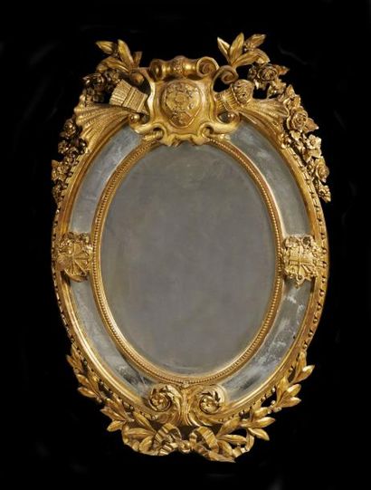 null IMPORTANT MIROIR à parecloses en bois sculpté et doré de forme ovale, à décor...