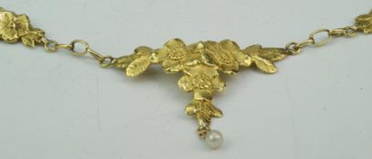 null Collier draperie en or jaune ciselé à décor de fleurs agrémenté d'une perle....