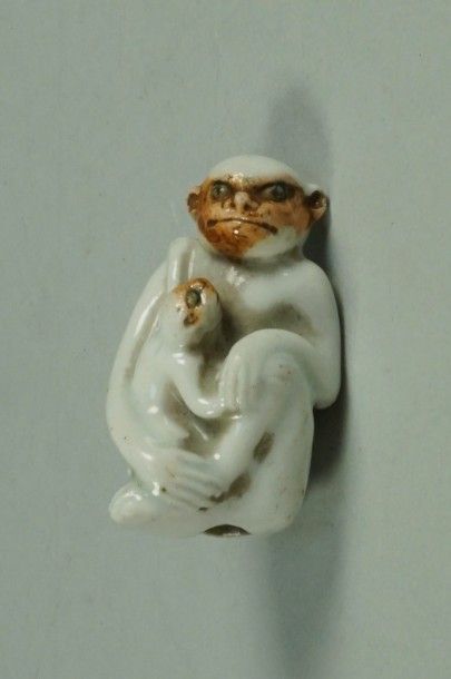 null Netsuké en porcelaine représentant un singe assis et son petit . (léger fêle)...