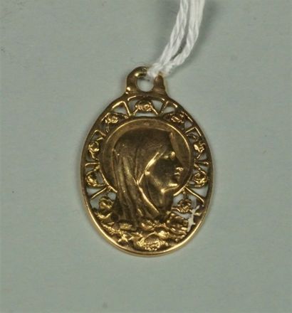 null Médaille ovale en or jaune 18K (750/oo) représentant la Vierge sur fond ajouré...