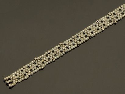 null Bracelet formé d'une résille de petites perles fines agrémenté de diamants taille...