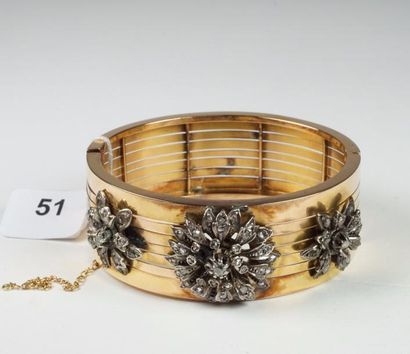 null Bracelet Jonc ouvrant en or jaune 18K (750/oo) agrémenté de trois motifs floraux...