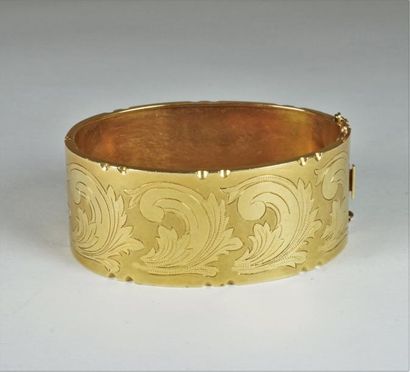 null Bracelet rigide en or jaune 18k ( 750°/°°) à décor ciselé de rinceaux feuillagés...