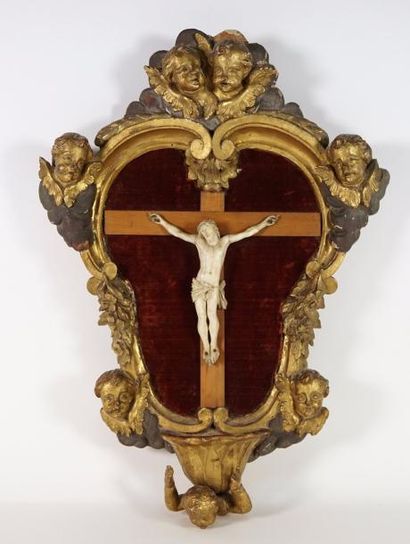 null Christ en ivoire dans un encadrement orné de putti, en bois doré. 43 x 30 cm...