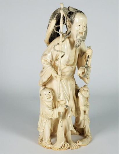 null Sujet en ivoire sculpté et réhaussé d’encre de Chine, représentant un pécheur...