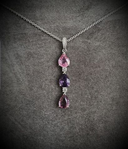 null White gold pendant on its chain supporting a trylogy of multicoloured natural...