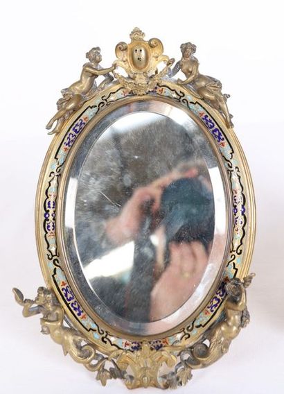 null A PAIR OF MIRRORS TO BE PLACED in oval form in gilt bronze with polychrome decoration...