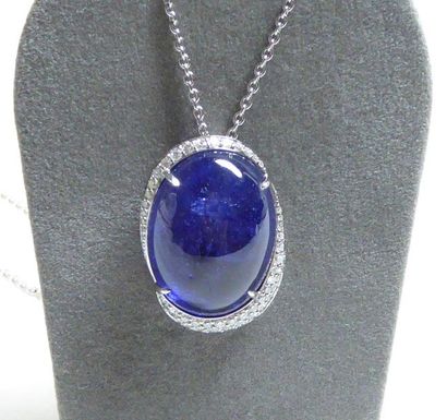 null White gold pendant supporting a large oval cabochon tanzanite weighing 26.18...