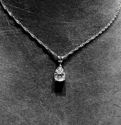 null White gold pendant on its chain holding a modern cut drop diamond weighing approx....