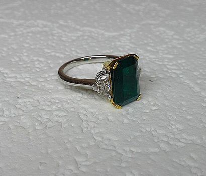 null Bi-color ring set with a NATURAL step-cut emerald weighing 5.09 c. with 2 troika...