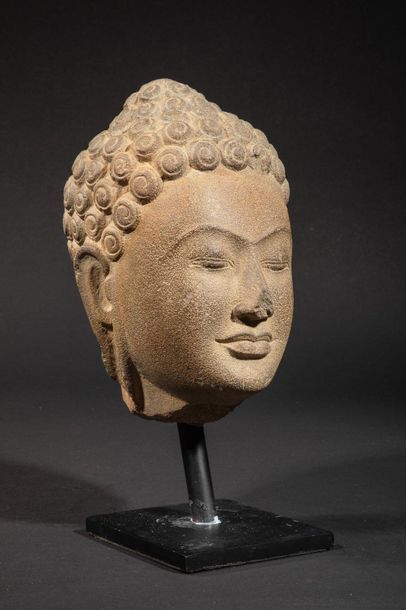 null Buddha's head with a serene expression and large curls chiselled into spirals,...