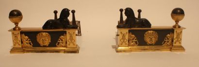 null PAIRE DE CHENETS En bronze doré et patiné, surmontés de deux sphinx affrontés...