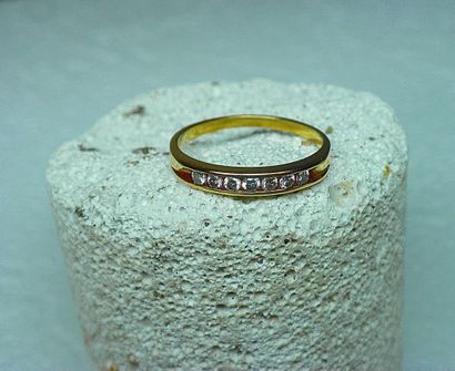 A yellow gold rail wedding ring set with...