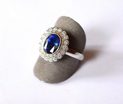 null Bague bicolore en clos d'un saphir ovale probablement Ceylan au bleu bleu intense...