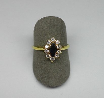 null Bague or jaune centrée d'un saphir navette dans un entourage d' oxydes de zirconium...