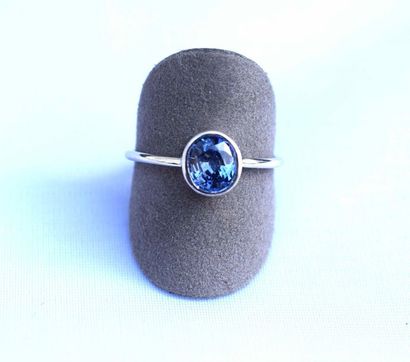 null Bague or blanc centrée en clos d'un saphir ovale probablement Ceylan d'un bleu...