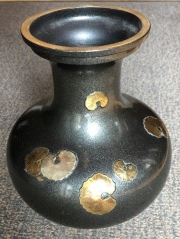 null Vase en bronze laqué à décor en relief de feuilles de nénuphars dorées et argentées....
