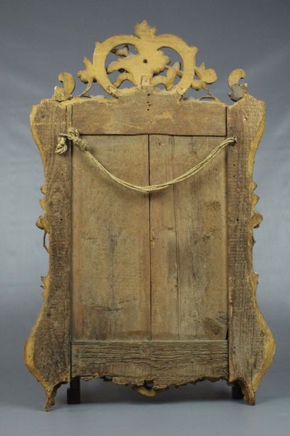 null Miroir d'entre-deux de style Louis XV en bois sculpté et doré au décor de branchages...
