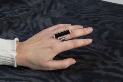 null 18K (750/1000) white gold scroll ring, the table topped by an onyx scroll with...