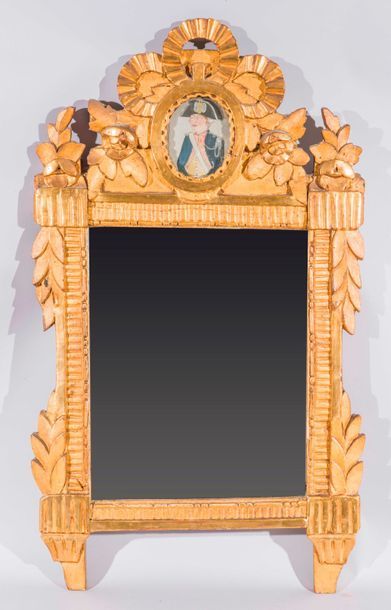 null Miroir dans un cadre en bois doré à décor de rubans et feuillages, le fronton...