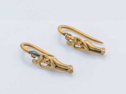 null Paire de boucles d’oreilles en métal doré à décor de petites figures ailées....