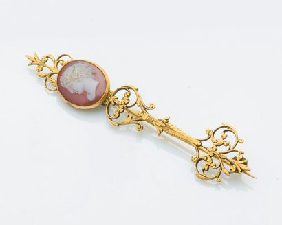 null Pin brooch in gilded metal drawing scrolls and set with an agate cameo depicting...