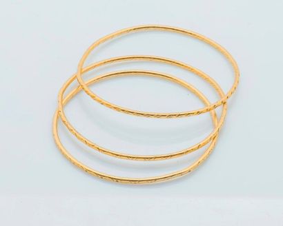 null Trois bracelets joncs en or jaune 18 carats (750 millièmes) à motifs ciselés....
