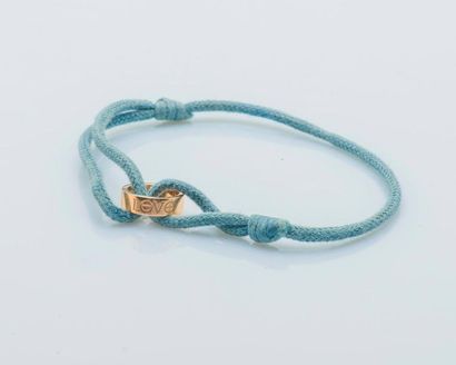 CARTIER Bracelet made of a blue cotton cord retaining in the center a circle in 18...