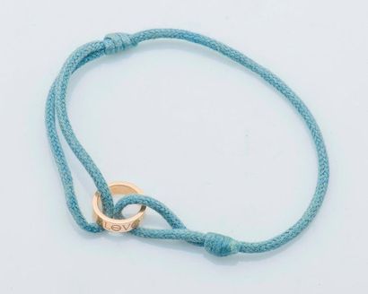 CARTIER Bracelet formé d'un cordon de coton bleu retenant au centre un cercle en...