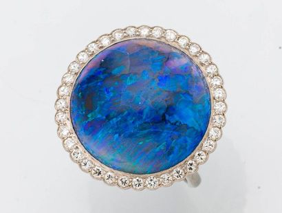 null Platinum ring (950 thousandths) set with a large blue opal cabochon in a setting...