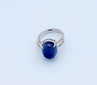 null 18 karat (750 thousandths) white gold ring set with an oval cabochon cut sapphire...