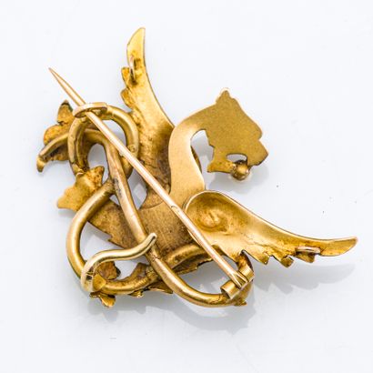 null 18 karat (750 thousandths) yellow gold brooch stylizing a winged chimera holding...