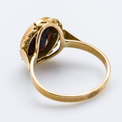 null 18 karat (750 thousandths) yellow gold ring set with an oval garnet in a twisted...