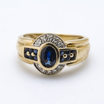 null 18 karat (750 thousandths) yellow gold ring set with an oval sapphire surrounded...