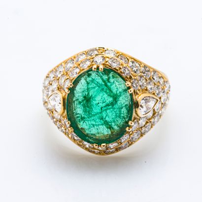 null 18 karat (750 thousandths) yellow gold ring set with an oval emerald of approximately...