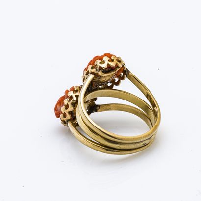 null 18 karat (750 thousandths) yellow gold ring decorated with two coral cabochons...